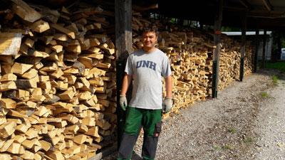 Waldprojekt- Mann vor Holzstapel